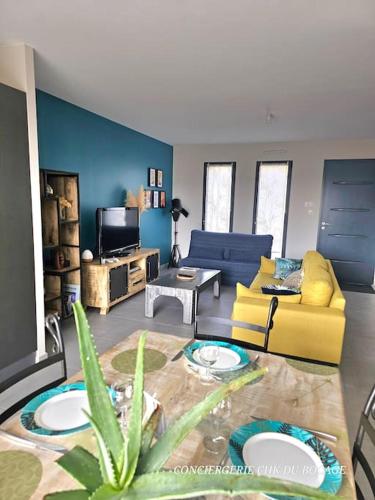 un salon avec un canapé et une table dans l'établissement L'Al'Oë charmant gîte - 2kms du Puy duFou, aux Épesses