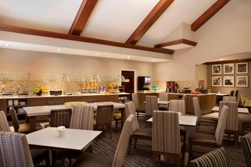 a restaurant with tables and chairs and a bar at Residence Inn by Marriott Toronto Airport in Toronto