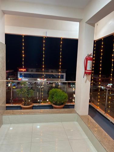 a balcony with potted plants and lights in a building at Swami Prasad Paradise hotel in Golitattu
