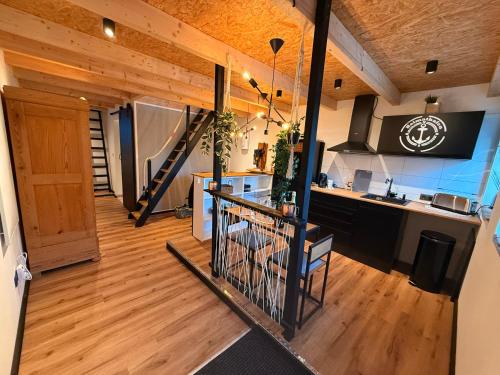 a kitchen with wooden floors and a staircase in a house at Ferienhaus ALTES FISCHERHAUS Kleve BED & BUBBLES in Kleve