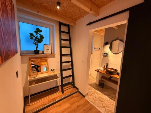 a room with a ladder and a bathroom with a window at Ferienhaus ALTES FISCHERHAUS Kleve BED & BUBBLES in Kleve