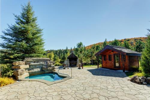a backyard with a hot tub and a cabin at Royal Laurentien in Mont-Blanc