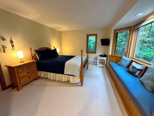 a bedroom with a bed and a couch in it at Bretton Woods home steps from the slopes, AC, pool passes, discounted cog tix! in Bretton Woods