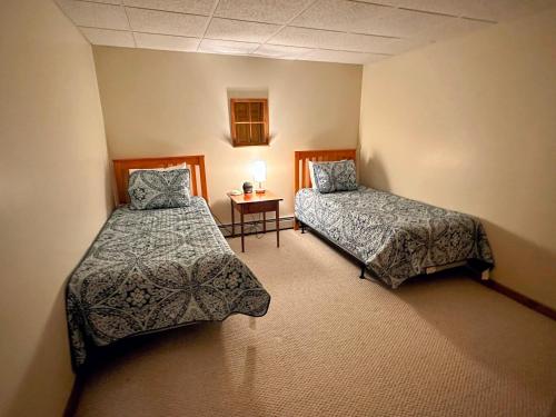 a room with two beds and a table in it at Bretton Woods home steps from the slopes, AC, pool passes, discounted cog tix! in Bretton Woods