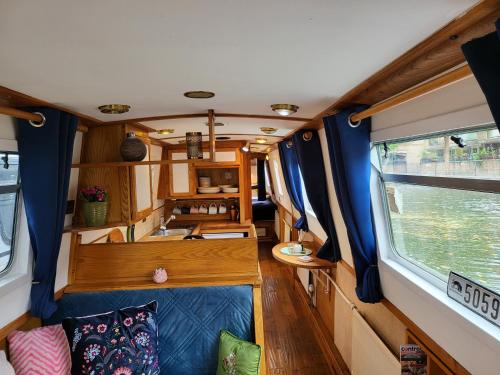 una habitación de tren con sofá y ventana en Cosy Canal Boat in Little Venice for Family & Friends, en Londres