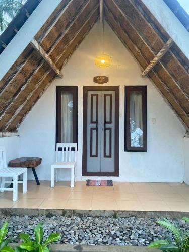a house with a wooden door and a bench at Alam Kowang Villa in Tejakula
