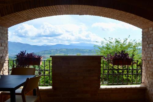 a window with a table and a view of mountains at Agriturismo Colle Mura in Morano Madonnuccia