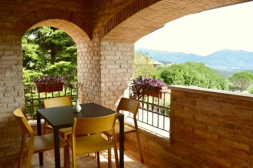 a patio with a table and chairs on a balcony at Agriturismo Colle Mura in Morano Madonnuccia