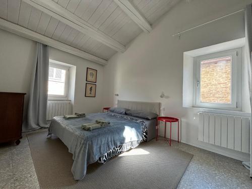 una camera da letto con un letto e due finestre di Maison62 a San Severino Marche