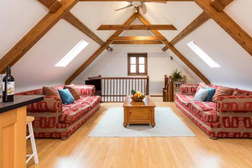 a living room with two couches and a table at The Hideaway-South Downs National Park in Graffham