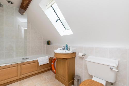a bathroom with a toilet and a sink and a bath tub at The Hideaway-South Downs National Park in Graffham
