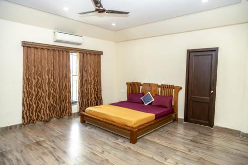 a bedroom with a bed with purple sheets and a window at Nahar Farmland - Green Heaven in Tirupporūr