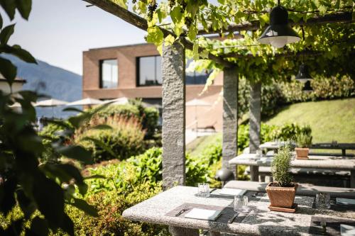 a patio with tables and trees and a building at Hotel Belvedere Locarno in Locarno