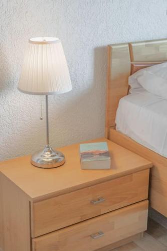 a lamp on a night stand next to a bed at 4BDR Alpine Chalet with Game room and Sunny terrace in Crans-Montana