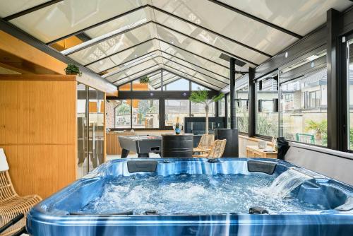 - une grande baignoire bleue au milieu d'une pièce dans l'établissement VILLA ARCADIA - Piscine - Spa - Sauna - Cinéma - Jeux d'arcades - Jeux vidéo - Bassin naturel - Jardin, à Seclin