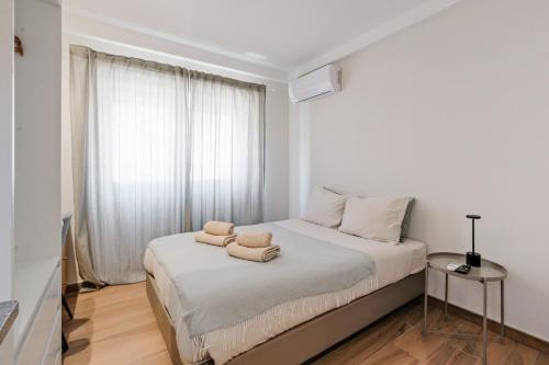a white bedroom with a bed with two pillows on it at Lovely studio fully equipped near subway N1 in Lisbon