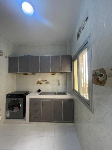 Una pequeña cocina con fregadero y ventana. en Racky, en Derklé