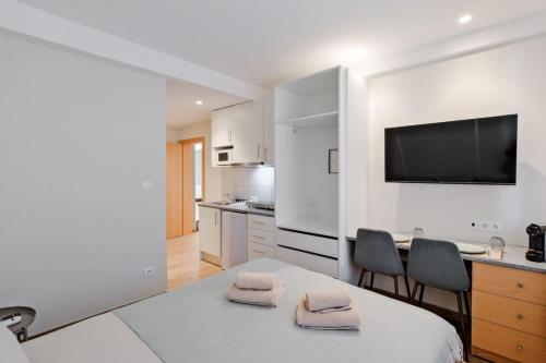 a white kitchen with a table and two chairs at Lovely studio fully equipped near subway N1 in Lisbon