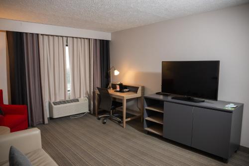 a hotel room with a television and a desk with a computer at Country Inn & Suites by Radisson, Erie, PA in Erie