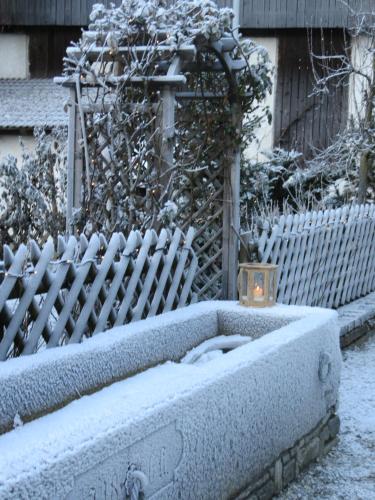 a stone box with a candle in front of a fence at Residence Obermoarhof - Family Apartments with Pool & Playground in Vandoies