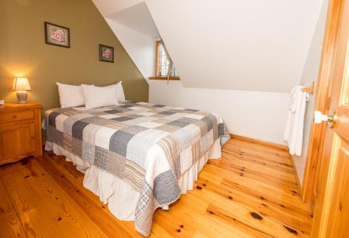 a bedroom with a bed and a wooden floor at Royal Laurentien in Mont-Blanc