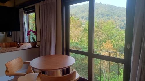 a room with a table and a large window at Pousada A Rosa e o Rei in São Francisco Xavier