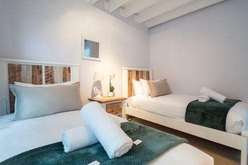 Un dormitorio con dos camas y una mesa. en Apartment near Hout Bay Harbour, en Ciudad del Cabo