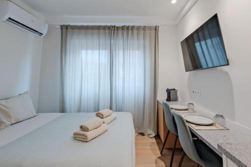 a hotel room with a bed and a desk with chairs at Lovely studio fully equipped near subway N6 in Lisbon
