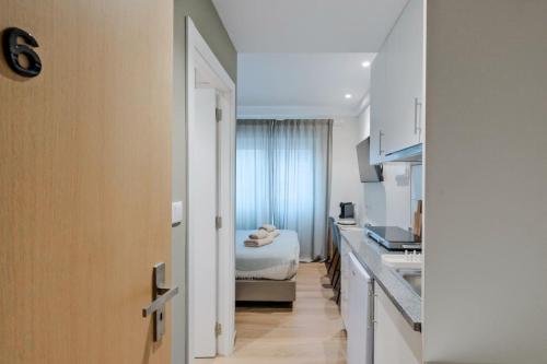 a small kitchen with a bed in a room at Lovely studio fully equipped near subway N6 in Lisbon