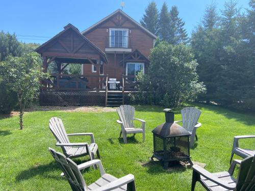 a group of chairs and a grill in front of a house at Royal Laurentien in Mont-Blanc
