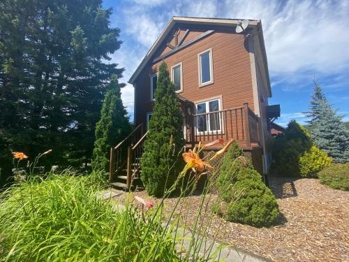a small house with a balcony and some plants at Royal Laurentien in Mont-Blanc