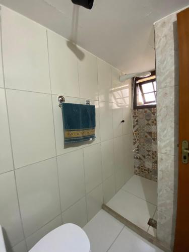 a bathroom with a toilet and a blue towel at Suíte Premium Sol in Miguel Pereira