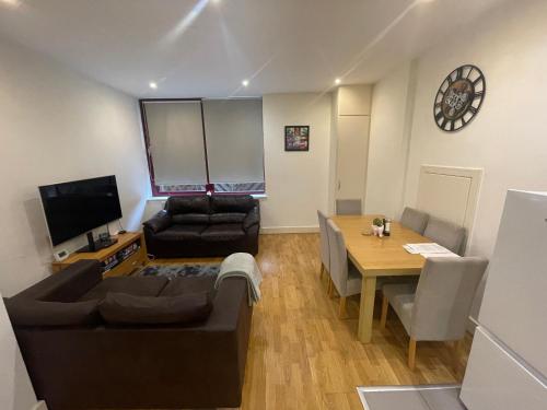 a living room with a couch and a table at Modern apartment 4 mins from Gatwick in Horley