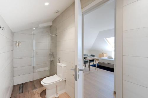 a white bathroom with a toilet and a table at Lovely studio fully equipped near subway N12 in Lisbon