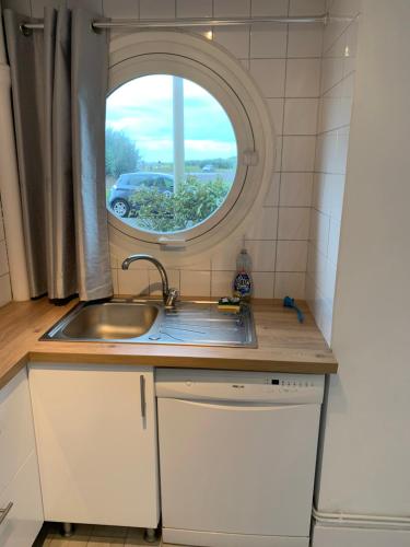 une cuisine avec un évier et une fenêtre dans l'établissement Appartement - bord de mer - Le Touquet - WIFI, à Le Touquet-Paris-Plage