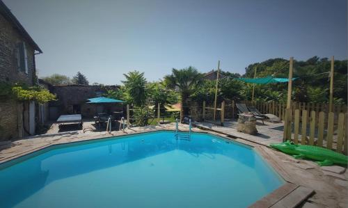 a large blue swimming pool in a yard at Les chambres du Nid charentais in La Poterie