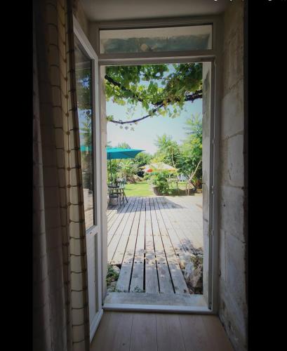 an open door with a view of a patio at Les chambres du Nid charentais in La Poterie