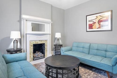 a living room with two blue couches and a table at Beautiful Rehabbed Unit in Shaw Community - 4226b in Tower Grove