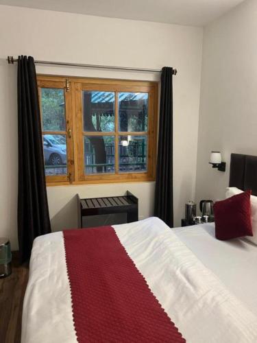 a bedroom with a bed and a window at The Boho Heritage Woods in Nainital