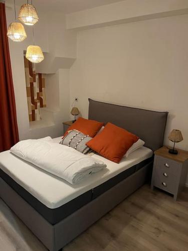 - un lit avec deux oreillers orange dans une chambre dans l'établissement Gold, 500 m du centre de Valence, à Bourg-lès-Valence