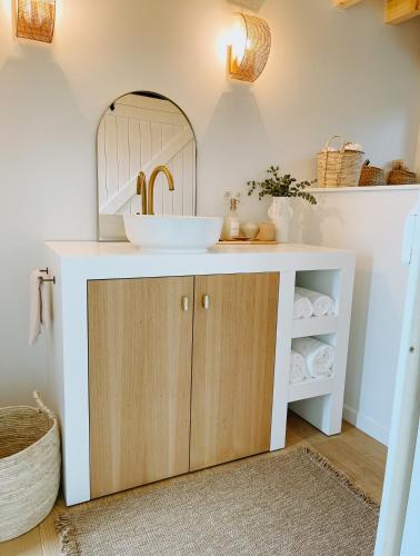 a bathroom with a sink and a mirror at La Cabane LeLa in Theux