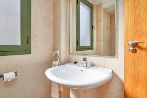 een badkamer met een witte wastafel en een spiegel bij Apartamento Balcon De Nerja I in Nerja