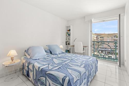 a white bedroom with a bed and a balcony at Un Air De Venise in Fréjus