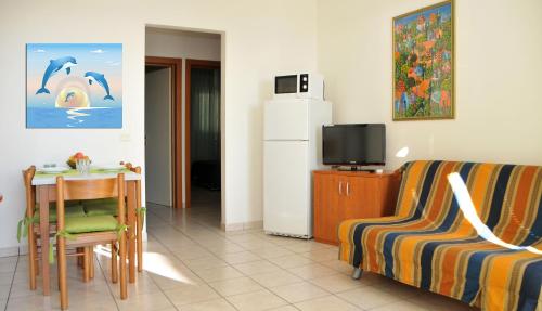 a living room with a couch and a table and a refrigerator at Isola di Pasqua in Caorle