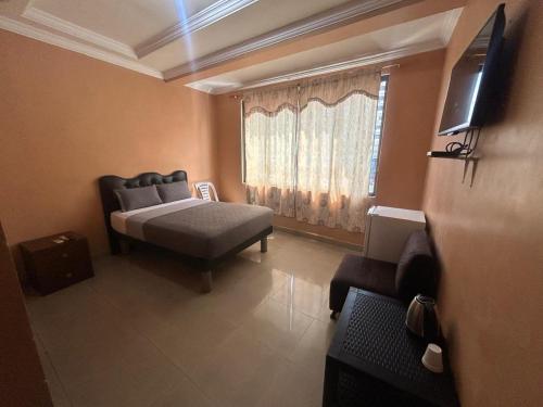 a living room with a bed and a window at Hotel Caribe in Guayaquil