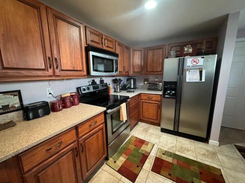a kitchen with wooden cabinets and a stainless steel refrigerator at Fenton Oasis in Fenton