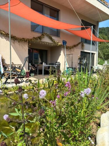 a garden with flowers in front of a house at Chez Svanette B&B Villa Sonnglück in Zullwil