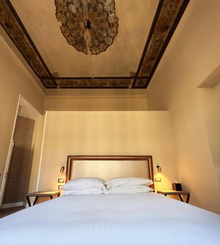 a bedroom with a large bed with a ceiling at Caruso Place Boutique & Wellness Suites in Naples