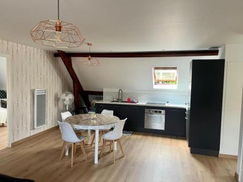 une cuisine et une salle à manger avec une table et des chaises dans l'établissement Logement avec parking Cité Médiévale, à Provins