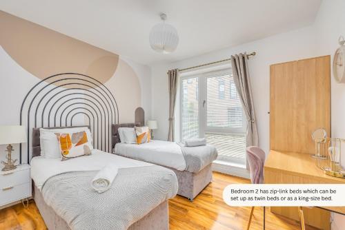 a bedroom with two beds and a window at Luxury 2 Bedroom 2 Bathroom Apartment - City Centre - Free Parking, Balcony and Smart TVs with Sky TV and Netflix by Yoko Property in Milton Keynes